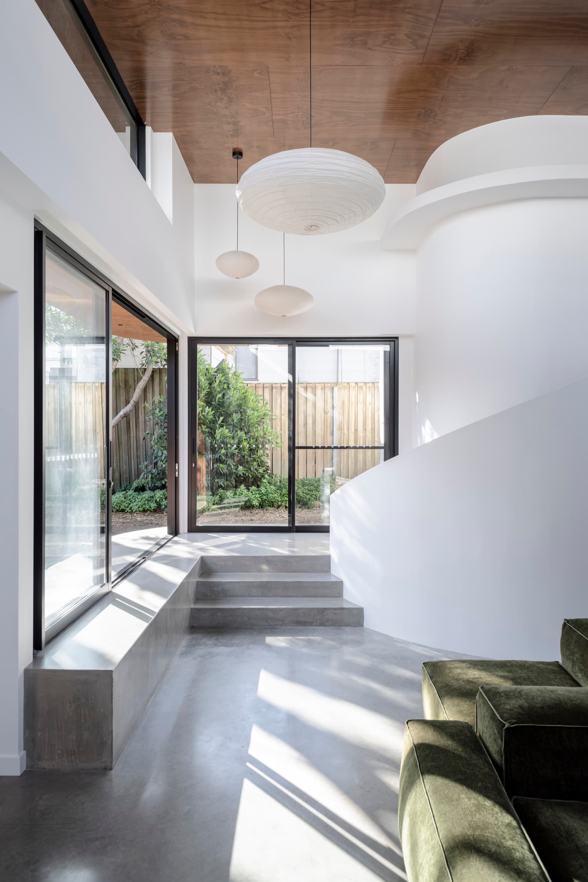 Art House interior — curved white walls, plywood ceiling and polished concrete with natural light