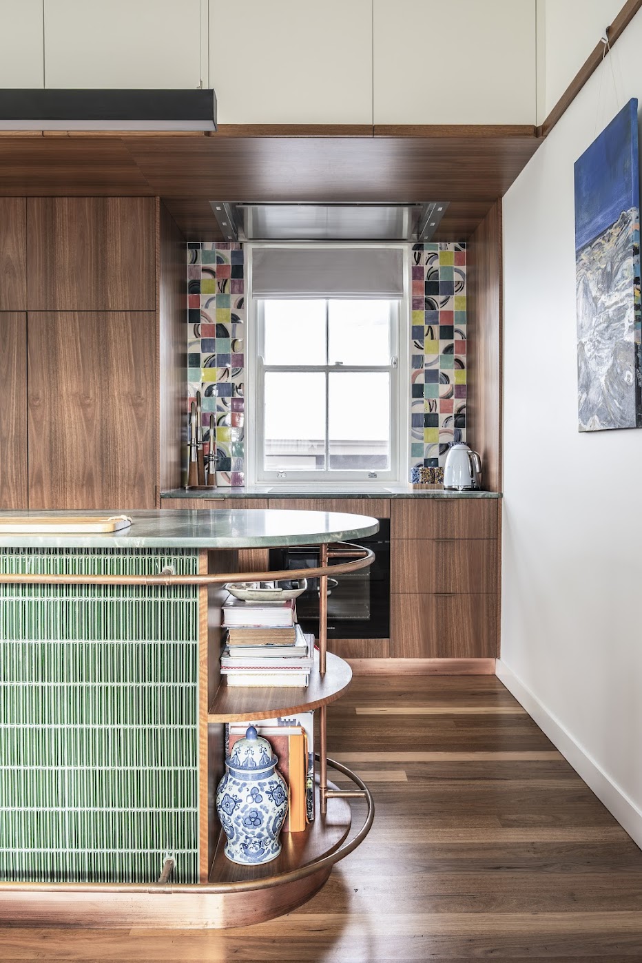 Kitchen detail — walnut cabinetry, colourful handmade tile splashback, green marble bench and green finger-tile island