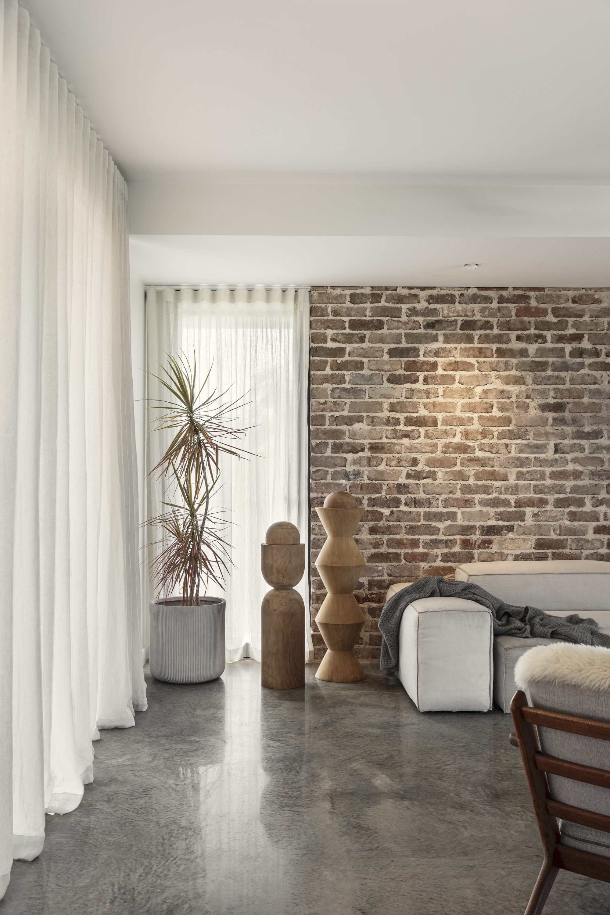 Bedroom with exposed brick wall and timber stool